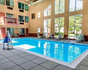 格里利Quality Inn and Conference Center Greeley Downtown的一座配有桌椅的酒店游泳池