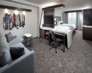 华盛顿华盛顿特区会议中心坎布里亚酒店的酒店客房配有一张床、一张书桌和一张沙发。