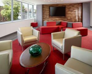 华盛顿华盛顿特区会议中心坎布里亚酒店的一间设有椅子、一张沙发和一台电视的等候室