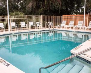 圣奥古斯丁海滩Quality Inn & Suites St Augustine Beach Area的一个带椅子的游泳池,海水蓝色