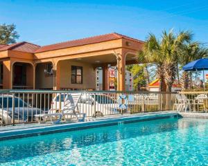 巴拿马城巴拿马城爱可诺汽车旅馆的一个带椅子和房子的度假胜地的游泳池