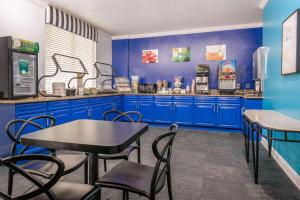 奥兰多Quality Inn & Suites Near the Theme Parks的厨房配有蓝色橱柜和桌椅
