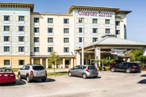 棕榈湾棕榈湾康福特套房酒店 - 墨尔本的停车场内有车辆的旅馆