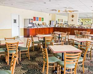 奥兰多Quality Inn & Suites Winter Park Village Area的一间带桌椅的用餐室和一间酒吧