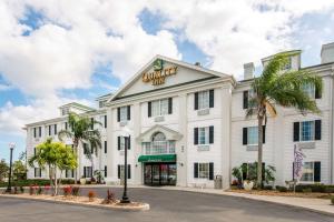 棕榈湾Quality Inn Palm Bay - Melbourne I-95的白色的建筑,上面有标志