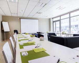 里昂Appart hôtel Q7 Lodge Lyon 7的一间会议室,配有长桌子、椅子和白板