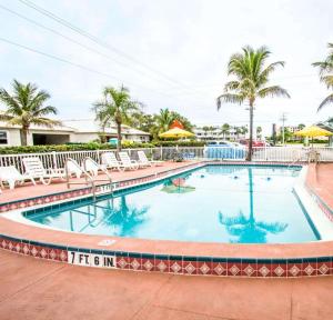 可可比奇可可海滩伊克诺旅馆 - 靠近港口的一座带椅子和棕榈树的度假村游泳池