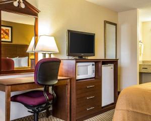 莫罗Quality Inn & Suites Morrow Atlanta South的酒店客房配有一张书桌、一台电视和一张床