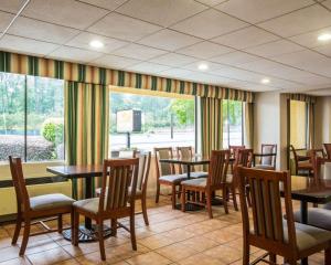 哥伦布Econo Lodge Inn & Suites at Fort Moore的一间带桌椅的用餐室和窗户。