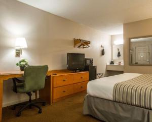 哥伦布Econo Lodge Inn & Suites at Fort Moore的酒店客房配有一张床和一张书桌及一台电视