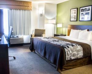 哥伦布Sleep Inn & Suites Columbus State University Area的酒店客房带一张大床和一把椅子