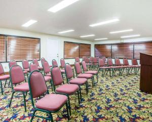 梅肯梅肯品质酒店的一间会议室,配有粉红色的椅子和讲台