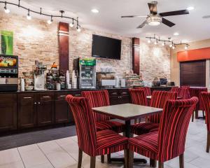 德梅因得梅因机场品质套房酒店的一间酒吧,餐厅里摆放着红色的椅子和桌子