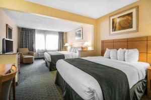 迪比克Quality Inn Dubuque on Hwy 20的酒店客房设有两张床和电视。
