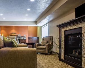 克拉尔维尔MainStay Suites Coralville - Iowa City的客厅设有壁炉和2把椅子