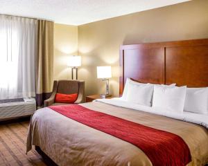 克拉尔维尔Comfort Inn & Suites Coralville - Iowa City near Iowa River Landing的酒店客房带一张大床和一把椅子
