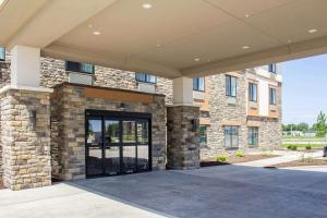 道奇堡Sleep Inn & Suites Fort Dodge的一座大型砖砌建筑,设有大玻璃门