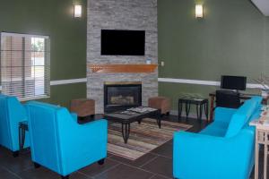 North VernonQuality Inn North Vernon near Hwy 50的客厅配有蓝色椅子和壁炉