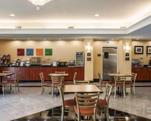 印第安纳波利斯Comfort Suites near Indianapolis Airport的一间带桌椅的餐厅和一间厨房