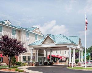 斯特布里奇Comfort Inn & Suites Sturbridge-Brimfield的前面有旗帜的房子