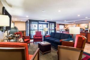 克林顿华盛顿特区安德鲁斯空军基地康福特茵酒店的客厅配有蓝色的沙发和红色的椅子