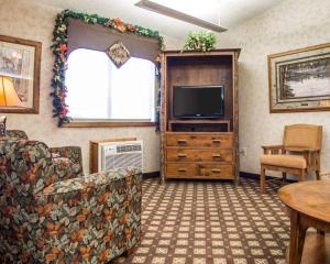 艾恩伍德Quality Inn Ironwood的客厅配有电视、沙发和桌子