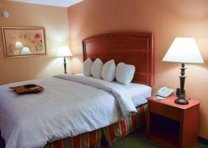 弗洛里森特圣路易斯西北品质酒店 I-270的酒店客房,配有带灯和电话的床