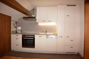 埃格Bauernhof Schneider的厨房配有白色橱柜和水槽