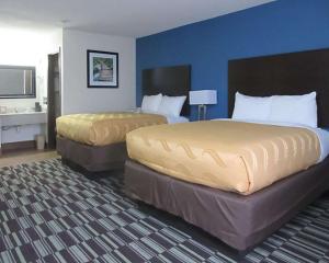 法明顿行政旅馆的两张位于酒店客房的床,拥有蓝色的墙壁