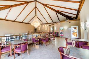 迦太基Quality Inn & Suites的一间带桌子和紫色椅子的用餐室