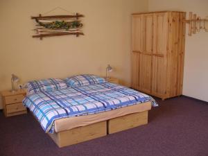 帕维西纳勒霍塔亚斯纳滑雪公寓式酒店的一间卧室配有一张床和一个木制橱柜