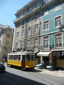 里斯本银色膳宿酒店的大楼前的一条街道上的黄色电车