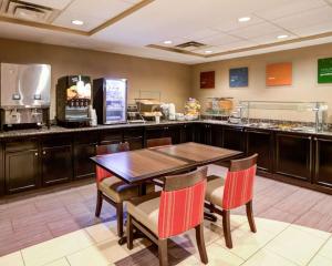 夏洛特Comfort Suites Charlotte Airport的一间带桌椅和柜台的餐厅