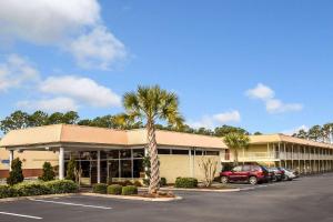 威尔明顿Rodeway Inn & Suites Wilmington North的停车场内有车辆的建筑物