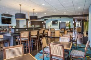 新伯尔尼Comfort Suites New Bern near Cherry Point的一间带桌椅的餐厅和一间酒吧