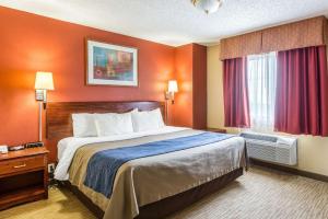 斯科茨布拉夫Quality Inn的酒店客房,设有一张带橙色墙壁的大床