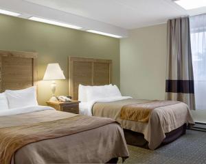 俾斯麦俾斯麦品质酒店的酒店客房,设有两张床和一盏灯