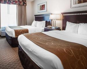 莫沃Tapa Hotel, Inn & Suites的酒店客房设有两张床和窗户。