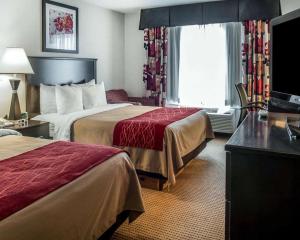 法明顿Quality Inn & Suites Farmington的酒店客房设有两张床和电视。