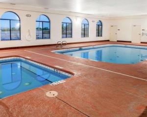 索科罗索科罗康福特茵套房酒店的一座大型游泳池,位于一座带窗户的建筑内