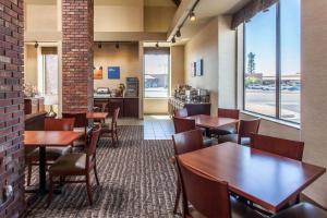 法伦Comfort Inn & Suites Near Fallon Naval Air Station的一间带木桌椅的餐厅和一间厨房