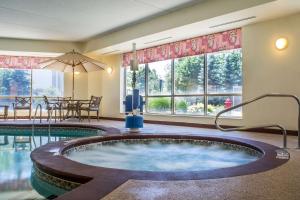 阿默斯特Sleep Inn的酒店带游泳池的客房内设有一个按摩浴缸。