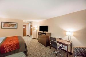 康宁Quality Inn的酒店客房配有一张床、一张书桌和一台电视。