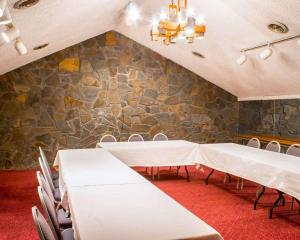 奥尔巴尼Econo Lodge Inn & Suites Colonie Center Mall的一间会议室,配有白色的桌椅和石墙