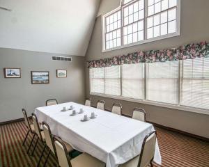Lakeville翠湖罗德威旅馆的一间会议室,配有桌椅和两个窗户
