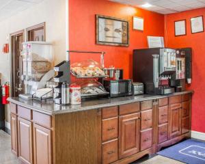亨廷顿Rodeway Inn Huntington Station - Melville的一间厨房,拥有橙色的墙壁和一个带食物的柜台