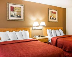 伊利里亚伊利里亚品质酒店的酒店客房,配有两张带红色床单的床