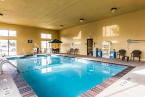 阿德莫尔阿德莫尔套房康福特茵酒店的酒店的大型游泳池配有桌椅