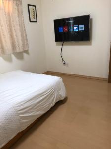 垂井町波萨达卡萨生态酒店的一间卧室配有一张床和一台平面电视