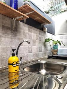 拜县班纳姆胡简易别墅旅馆的有一个装有玻璃杯的黄色容器,坐在厨房水槽上